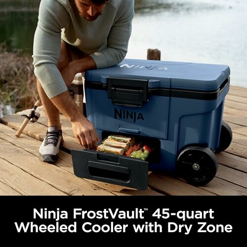 Person using Ninja FrostVault 45-quart wheeled cooler with dry zone.